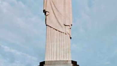 Imagem impressionante do Cristo Redentor, majestosamente situado no topo do morro do Corcovado, no Rio de Janeiro. A estátua icônica com os braços abertos em um gesto de acolhimento e paz, contrastando com o céu azul e a paisagem exuberante ao redor. Uma representação imponente da cultura e da fé brasileira.