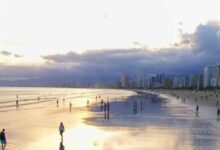 Ao olhar para a foto do pôr do sol na Praia Grande, é possível sentir uma sensação de paz e serenidade. O sol está se pondo no horizonte, tingindo o céu de tons alaranjados e vermelhos, enquanto a silhueta de palmeiras e coqueiros se destaca contra o céu. As ondas suaves do mar e a brisa fresca completam a atmosfera relaxante e envolvente do cenário. A Praia Grande é um dos destinos mais populares da região, e oferece uma variedade de opções de lazer e entretenimento para os visitantes. Durante o dia, é possível se refrescar nas águas claras da praia, praticar esportes aquáticos, ou simplesmente relaxar ao sol em uma das muitas cadeiras de praia disponíveis. À noite, a praia se transforma em um ponto de encontro para os moradores locais e turistas, com uma animada vida noturna que inclui bares, restaurantes e shows. Mas é no pôr do sol que a Praia Grande revela sua verdadeira magia. O espetáculo da natureza é uma atração imperdível, e muitos visitantes se reúnem na praia para admirar o sol se pôr no horizonte. É um momento de contemplação e reflexão, onde se pode apreciar a beleza da vida e da natureza, e sentir-se em paz consigo mesmo e com o mundo ao redor. Em resumo, a Praia Grande é um destino completo, que oferece belezas naturais, atividades de lazer, boa infraestrutura e uma atmosfera acolhedora e envolvente. A foto do pôr do sol é um lembrete daquilo que a praia tem de melhor: uma beleza natural indescritível, que se mistura com a alegria e a vitalidade de seus visitantes. Certamente, um destino que vale a pena conhecer e explorar.