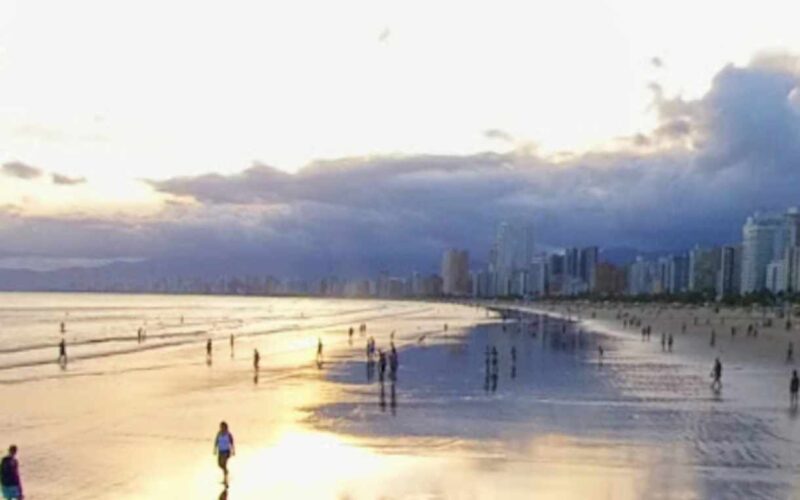 Ao olhar para a foto do pôr do sol na Praia Grande, é possível sentir uma sensação de paz e serenidade. O sol está se pondo no horizonte, tingindo o céu de tons alaranjados e vermelhos, enquanto a silhueta de palmeiras e coqueiros se destaca contra o céu. As ondas suaves do mar e a brisa fresca completam a atmosfera relaxante e envolvente do cenário. A Praia Grande é um dos destinos mais populares da região, e oferece uma variedade de opções de lazer e entretenimento para os visitantes. Durante o dia, é possível se refrescar nas águas claras da praia, praticar esportes aquáticos, ou simplesmente relaxar ao sol em uma das muitas cadeiras de praia disponíveis. À noite, a praia se transforma em um ponto de encontro para os moradores locais e turistas, com uma animada vida noturna que inclui bares, restaurantes e shows. Mas é no pôr do sol que a Praia Grande revela sua verdadeira magia. O espetáculo da natureza é uma atração imperdível, e muitos visitantes se reúnem na praia para admirar o sol se pôr no horizonte. É um momento de contemplação e reflexão, onde se pode apreciar a beleza da vida e da natureza, e sentir-se em paz consigo mesmo e com o mundo ao redor. Em resumo, a Praia Grande é um destino completo, que oferece belezas naturais, atividades de lazer, boa infraestrutura e uma atmosfera acolhedora e envolvente. A foto do pôr do sol é um lembrete daquilo que a praia tem de melhor: uma beleza natural indescritível, que se mistura com a alegria e a vitalidade de seus visitantes. Certamente, um destino que vale a pena conhecer e explorar.